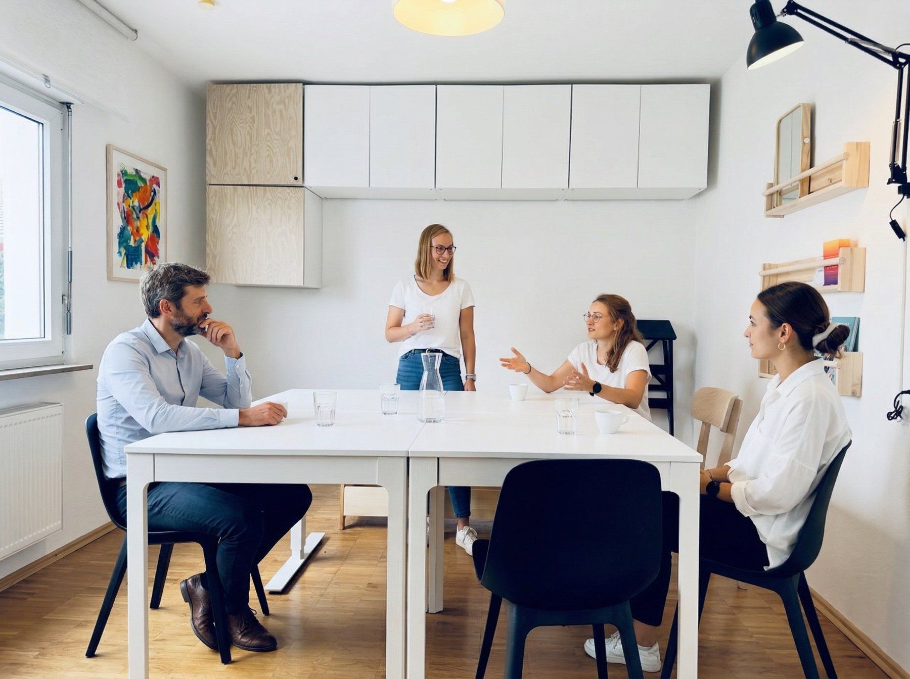 Das Team von ergo momentum im Gespräch am Tisch im Behandlungsraum